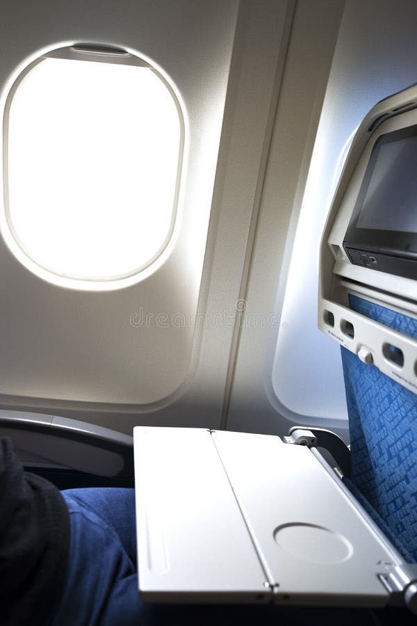 Flygplanmagasintabellen öppnade på plats tillbaka vid fönstret royaltyfri foto Flygplanmagasintabellen öppnade på plats tillbaka vid fönstret royaltyfri foto