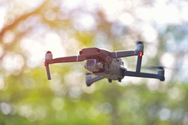 Flying drone with camera hovering inside a forrest, natural background stock image Flying drone with camera hovering inside a forrest, natural background stock image