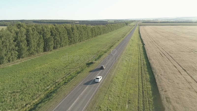 Copter flight over the car in the field and on the highway