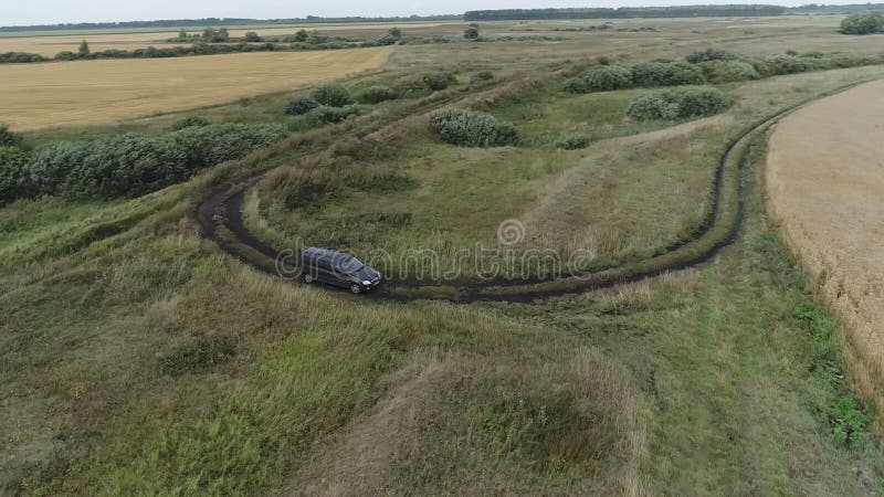 Copter flight over the car in the field and on the highway