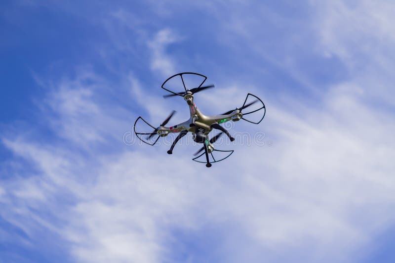 Flying Drone with Remote Control Against Blue Sky Background Stock