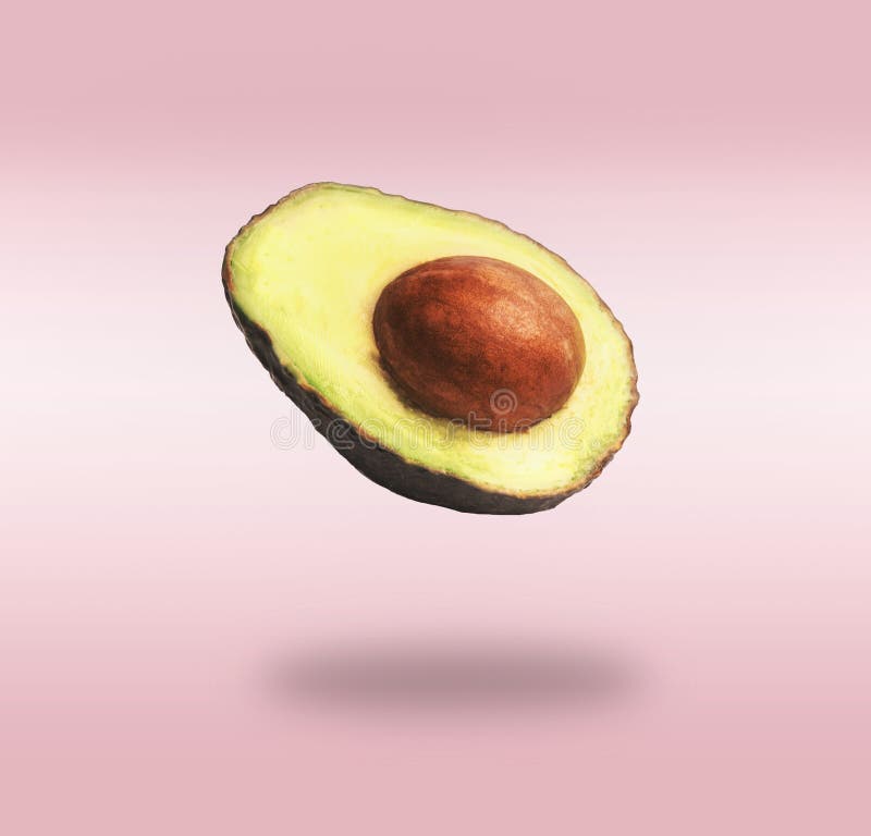 Flying half avocado with seed at pink background with shadow. Concept of food levitation stock images