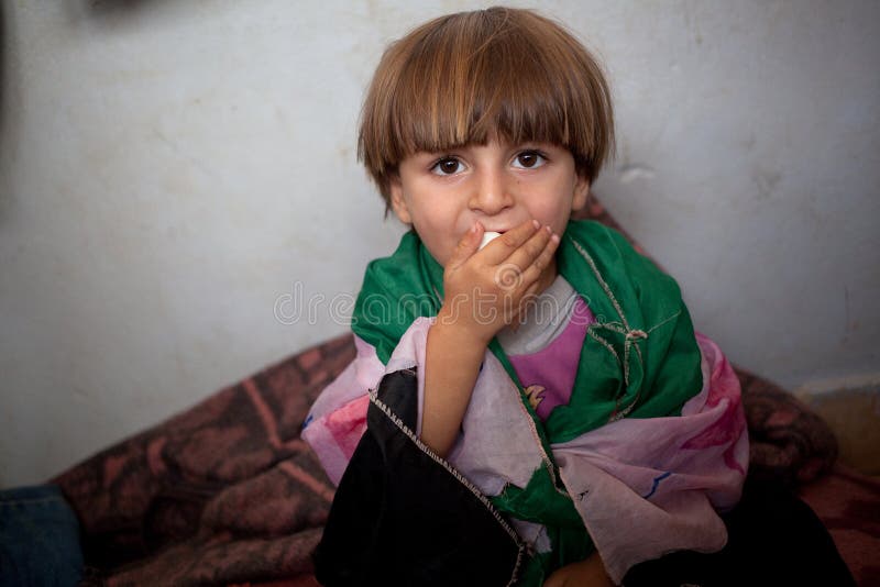 Flyktingbarn som slås in i den hemlagade fria syrianska flaggan, Atmeh, Syrien. royaltyfri foto Flyktingbarn som slås in i den hemlagade fria syrianska flaggan, Atmeh, Syrien. royaltyfri foto