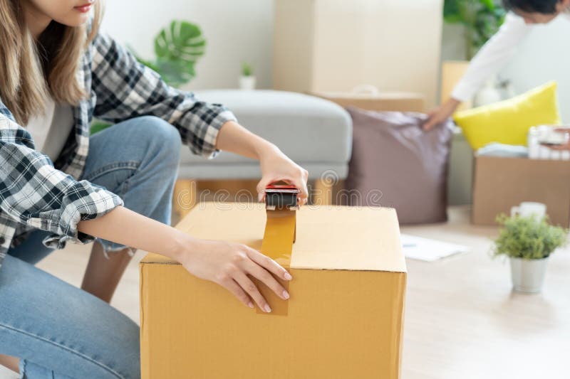 Moving house, relocation. Couple help set and move furniture for new apartment, inside the room was a cardboard box contain personal belongings. move in the new apartment or condominium. Moving house, relocation. Couple help set and move furniture for new apartment, inside the room was a cardboard box contain personal belongings. move in the new apartment or condominium