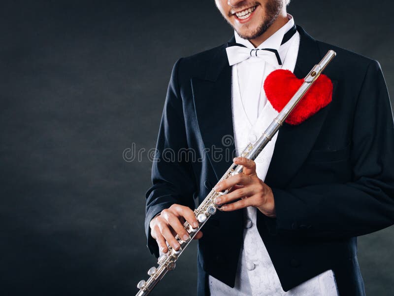 Flûtiste masculin avec la cannelure et le coeur Mélodie d'amour photographie stock libre de droits Flûtiste masculin avec la cannelure et le coeur Mélodie d'amour photographie stock libre de droits
