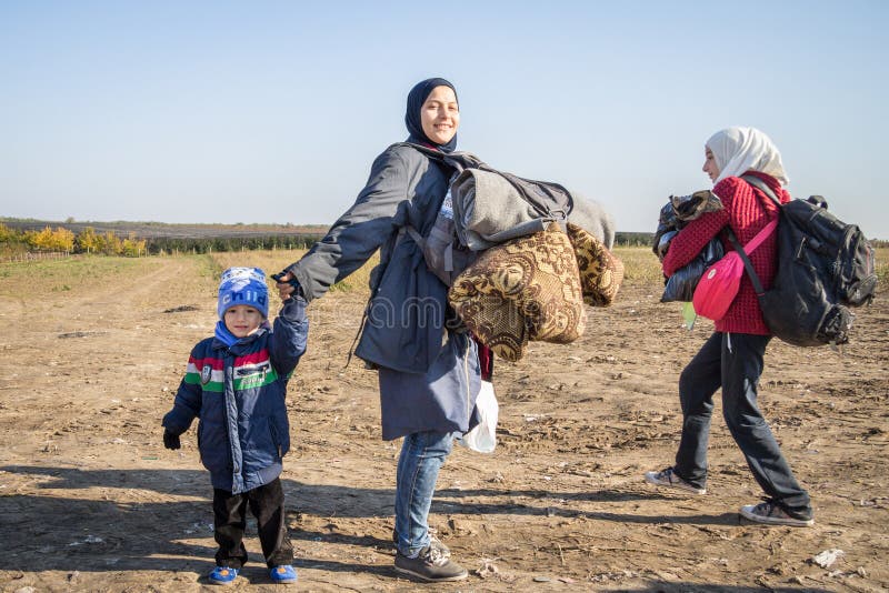 Flüchtlingsfrau umgeben von den Kindern, die zur Grenze Kroatiens Serbien, zwischen die Städte von Bapska und Berkasovo gehen