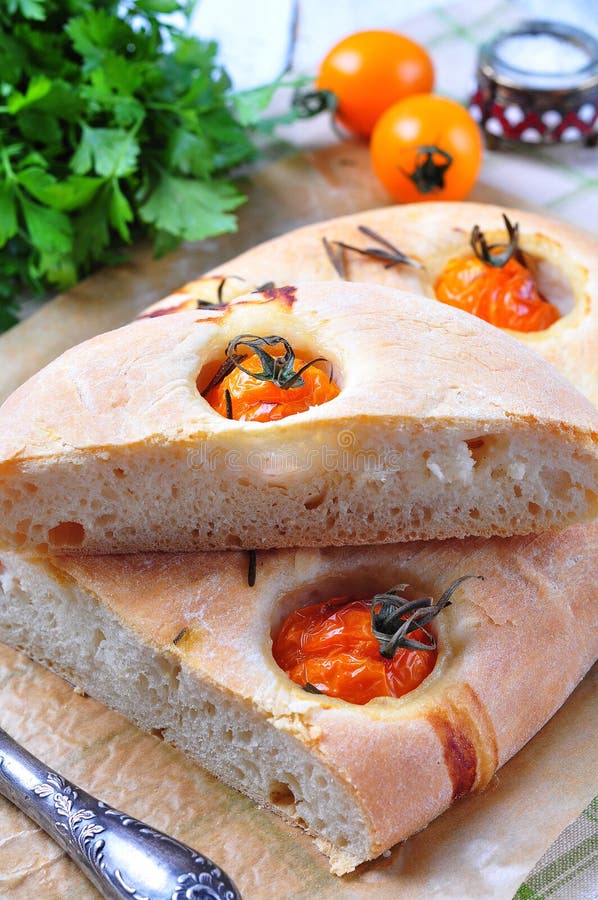 Focaccia caseiro com os tomates de cereja amarelos orgânicos e alecrins secados imagem de stock royalty free Focaccia caseiro com os tomates de cereja amarelos orgânicos e alecrins secados imagem de stock royalty free