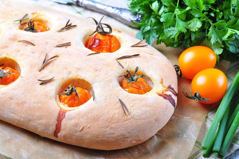 Focaccia caseiro com os tomates de cereja amarelos orgânicos e alecrins secados fotografia de stock Focaccia caseiro com os tomates de cereja amarelos orgânicos e alecrins secados fotografia de stock