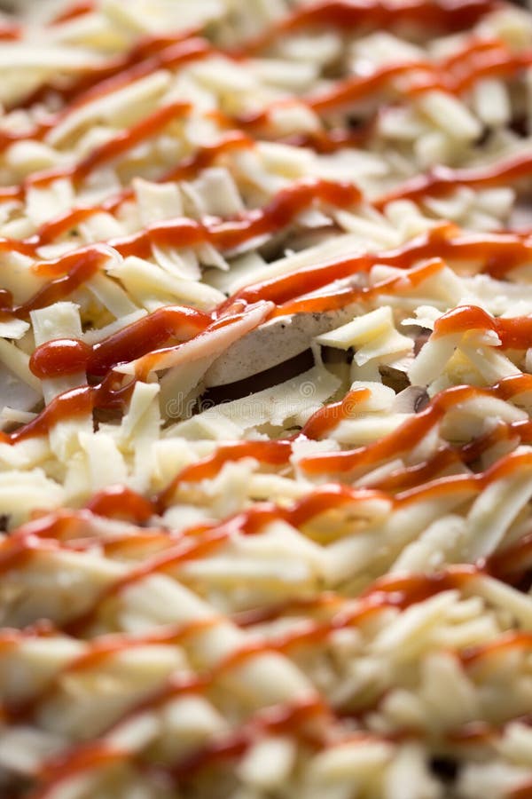 Foco seletivo com profundidade de campo rasa na pizza crua com cogumelos e ketchup fotografia de stock Foco seletivo com profundidade de campo rasa na pizza crua com cogumelos e ketchup fotografia de stock