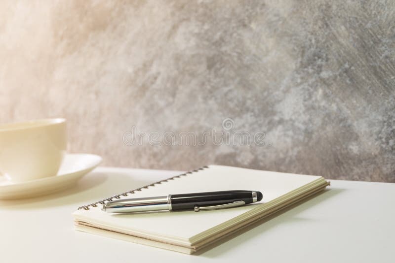 Focus of blank book, pen and white coffee cup stock images Focus of blank book, pen and white coffee cup stock images