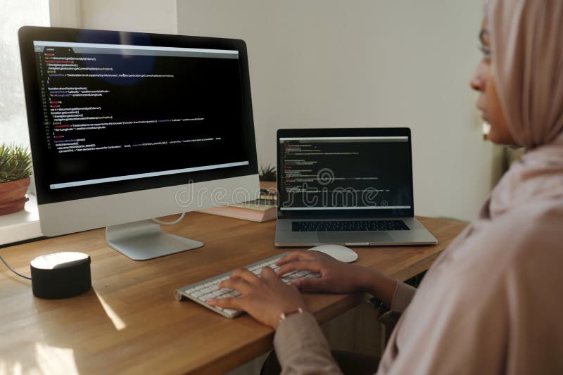 Focus on hands of young Muslim female programmer decoding data stock images