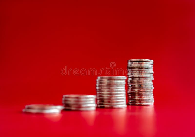 Focus on the highest coin stacks as graph chart steps isolated on red background. Investment, saving money, financial income, sales increase, inflation, business marketing growth concepts.