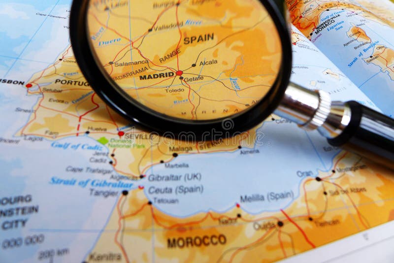 Focusing on Madrid - A photograph showing a magnifying glass looking for and focusing on the European city of Madrid, Spain, on a world map. Radial blur applied to the other region of the image. World travels concept picture. Focusing on Madrid - A photograph showing a magnifying glass looking for and focusing on the European city of Madrid, Spain, on a world map. Radial blur applied to the other region of the image. World travels concept picture.