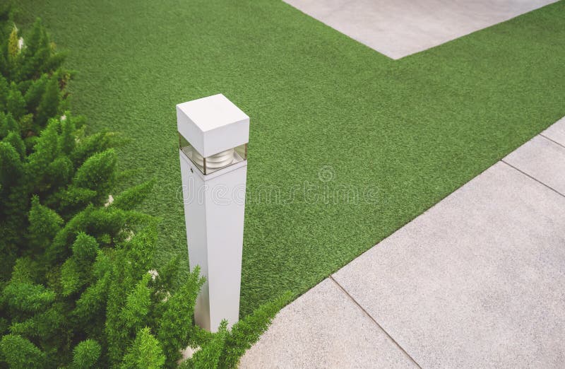 Focus at white light bollard on artificial turf and gravel stone walkway in front yard area