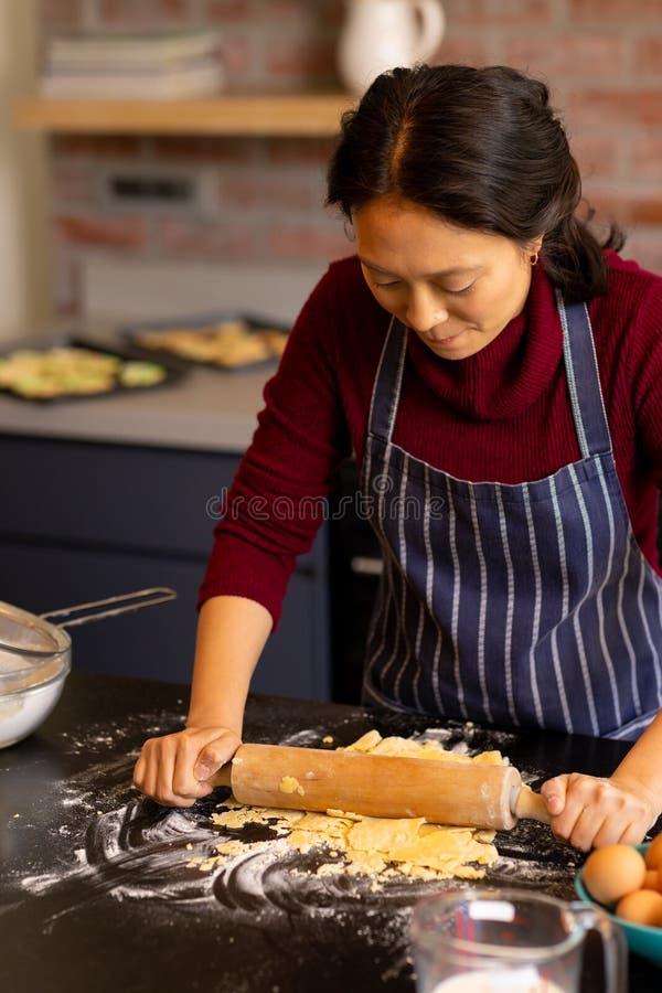 Focused Asian Woman Baking Rolling Dough In Kitchen Stock Photo Image Focused Asian Woman Baking Rolling Dough In Kitchen Stock Photo Image
