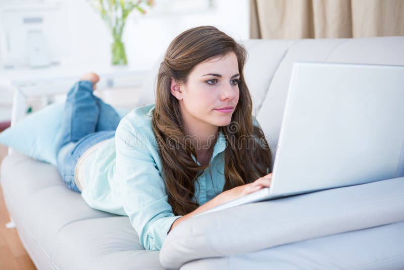 Focused Brunette on Couch Using Her Laptop Stock Image - Image of abode ...