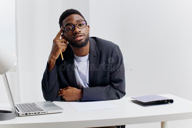 Profesioniștii concentrați la birou, cu ochelari de laptop și de stilou și cu gândire profundă stock images
