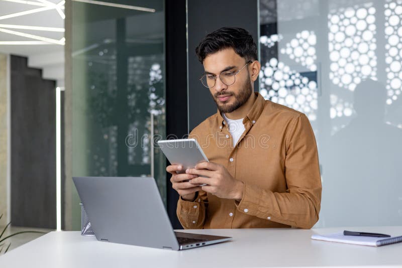 Profesioniștii concentrați care lucrează cu o tabletă într-un mediu de birou modern stock image