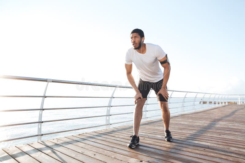 Focused sportsman is ready to start running on pier