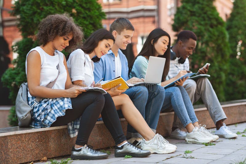 Focused students preparing for exams outdoors in the university courtyard royalty free stock photography