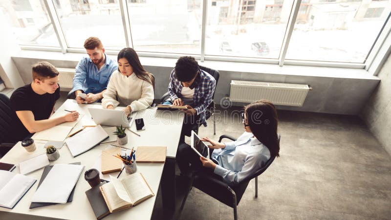 Focused students sitting in library, getting ready for exams stock photography