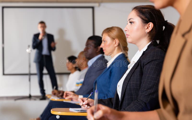 Focused woman listening to lecture at conference stock photography