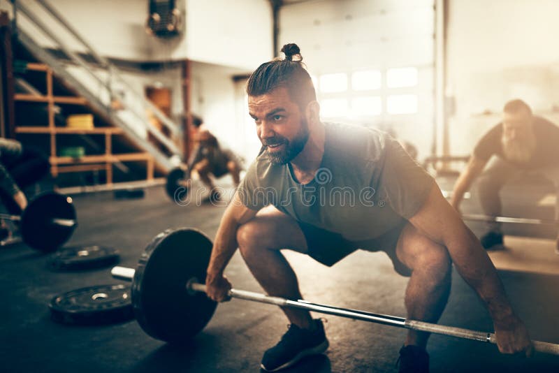 Focused young man preparing to lift weights during a workout royalty free stock image Focused young man preparing to lift weights during a workout royalty free stock image