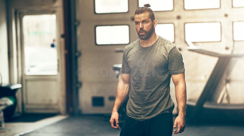 Focused young man in sportswear standing alone in a gym stock photos Focused young man in sportswear standing alone in a gym stock photos