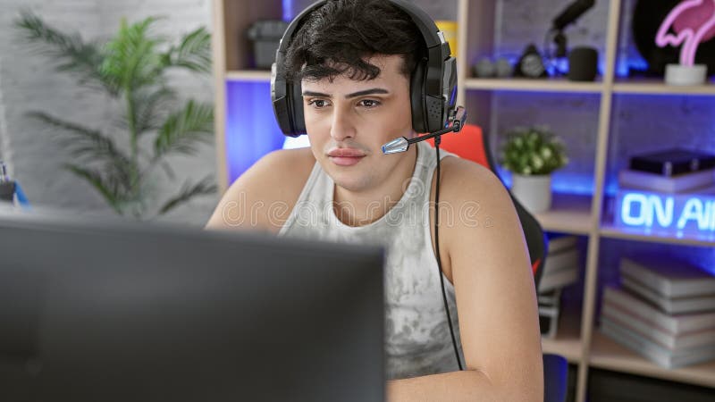 Focused young man wearing a headset streams video games from a vibrant home gaming room at night royalty free stock images