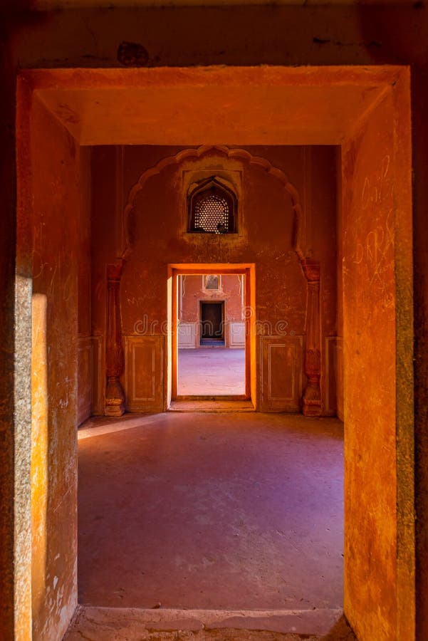 Fodrade dörrar och passager i apelsin tonade korridoren med dekorerade väggar Inre av den majestätiska Amber Fort, Jaipur, loppde arkivbild Fodrade dörrar och passager i apelsin tonade korridoren med dekorerade väggar Inre av den majestätiska Amber Fort, Jaipur, loppde arkivbild