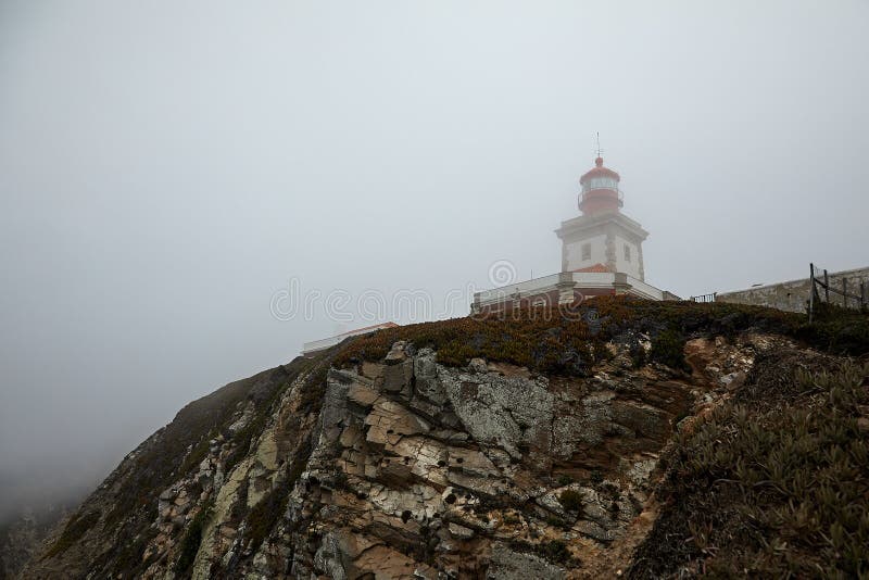 Fog omhult een vuurtoren op Cape Cabo da Roca in de buurt van Cascais, Portugal Afbeelding van slecht weer, slecht zicht op zee A royalty-vrije stock fotografie Fog omhult een vuurtoren op Cape Cabo da Roca in de buurt van Cascais, Portugal Afbeelding van slecht weer, slecht zicht op zee A royalty-vrije stock fotografie