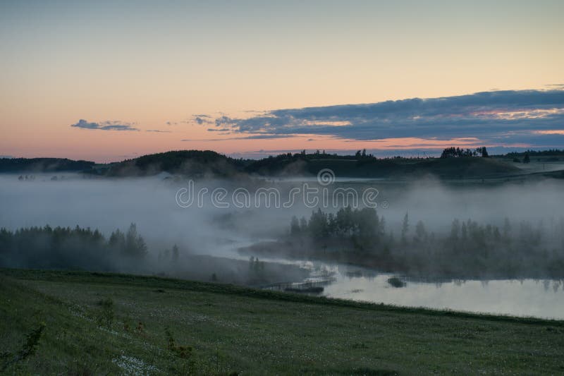 Fog over the swampy river before sunrise