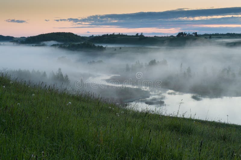Fog over the swampy river before sunrise