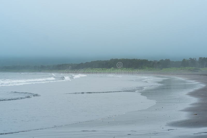 Foggy coast of Kunashir island during overcast stock photography