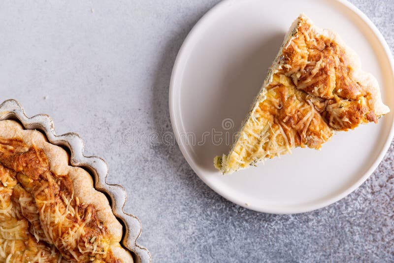 Fogliame di leftover tradizionale di quiche francese di torte di lorraina con formaggio di feta e spinaci in piastra di ceramica immagini stock