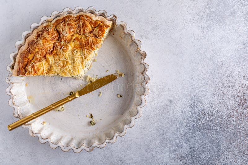 Fogliame di leftover tradizionale di quiche francese di torte di lorraine con formaggio di feta e spinaci in una teglia di ceramic immagini stock libere da diritti