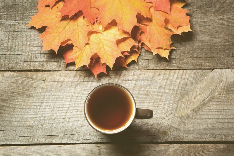 Foglie di autunno variopinte e tazza di caffè nero sul bordo di legno Natura morta di caduta, spazio della copia immagini stock libere da diritti