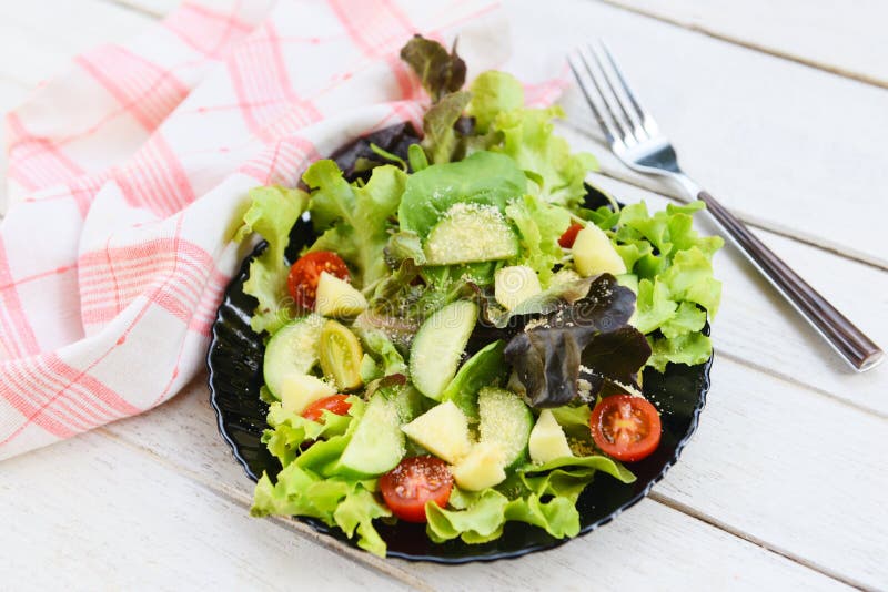 Foglie di ortaggi e legumi salati mescolano l'insalata con la frutta e il cetriolo di pomodoro di lattuga fresco su piastra di ali immagine stock libera da diritti
