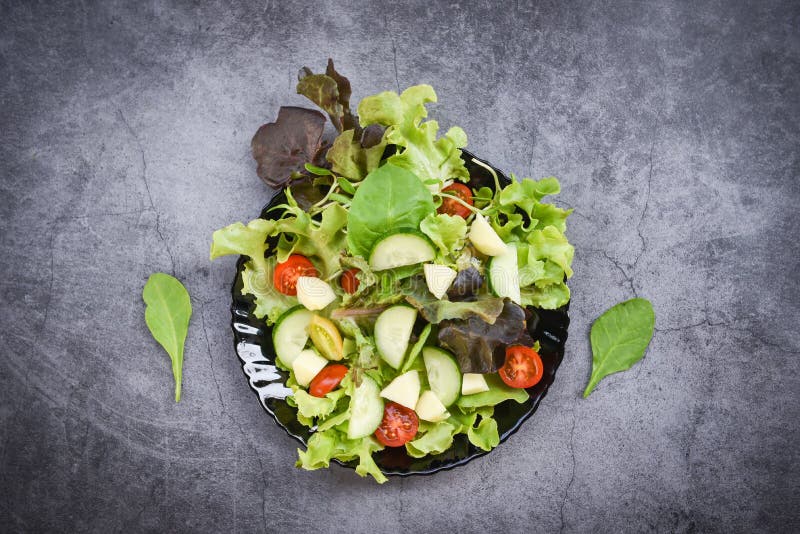 Foglie di ortaggi e legumi salati mescolano l'insalata con la frutta e il cetriolo di pomodoro di lattuga fresco su piastra di ali fotografia stock libera da diritti
