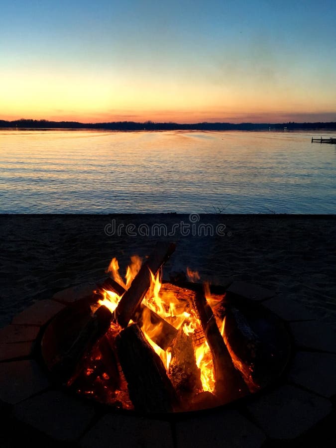 Fogueira do por do sol na praia no lago Chippewa, Michigan foto de stock royalty free Fogueira do por do sol na praia no lago Chippewa, Michigan foto de stock royalty free