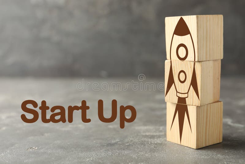 Foguete feito de cubos e inicialização de texto em fundo cinza imagens de stock