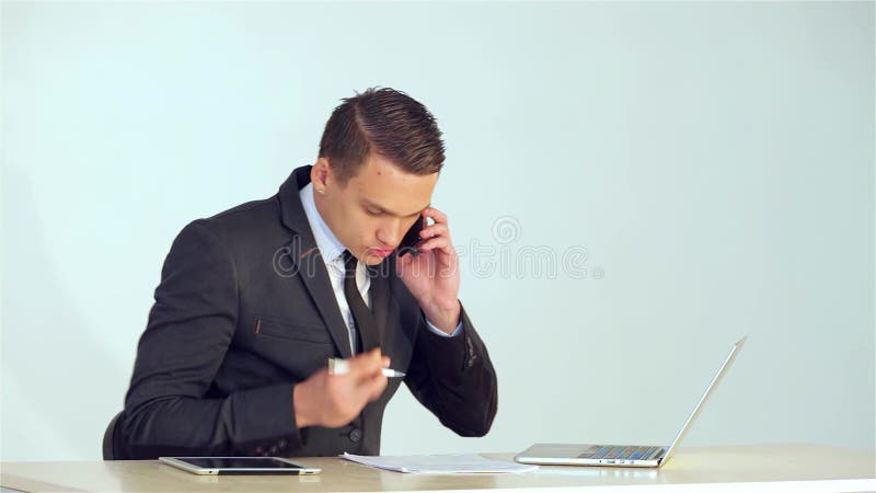 Fokuserad ung affärsman som analyserar data på sin bärbara dator stock video