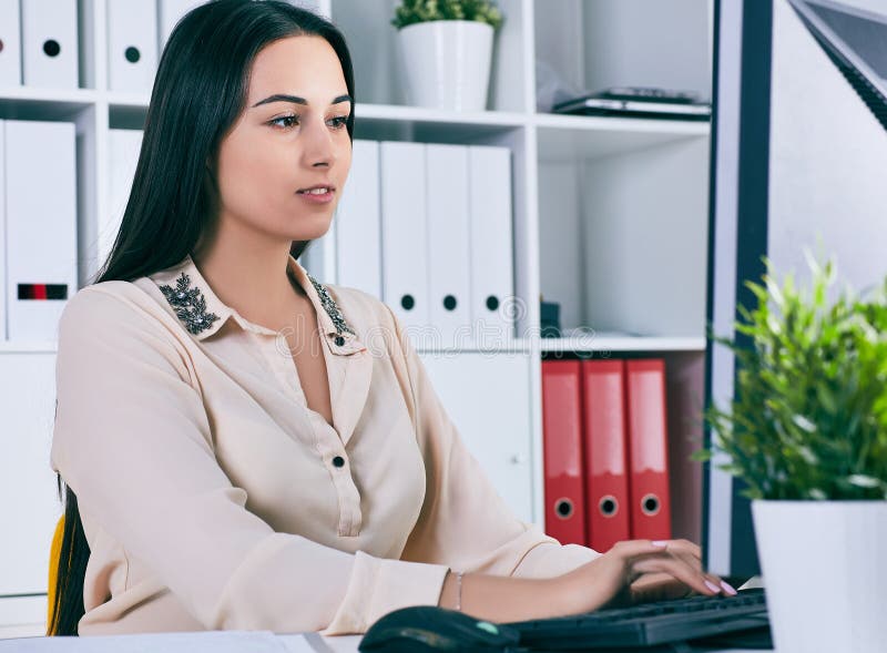 Fokussierte Geschäftsfrau, die am Schreibtisch im kreativen Büro arbeitet lizenzfreie stockfotografie Fokussierte Geschäftsfrau, die am Schreibtisch im kreativen Büro arbeitet lizenzfreie stockfotografie