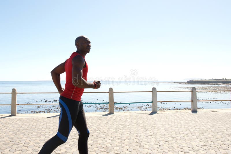 Fokussierter geeigneter afrikanischer Mann, der an der Promenade rüttelt lizenzfreie stockfotografie Fokussierter geeigneter afrikanischer Mann, der an der Promenade rüttelt lizenzfreie stockfotografie