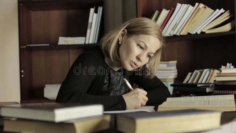 Fokussierter Student, der für Prüfungen in der Bibliothek im College sich vorbereitet