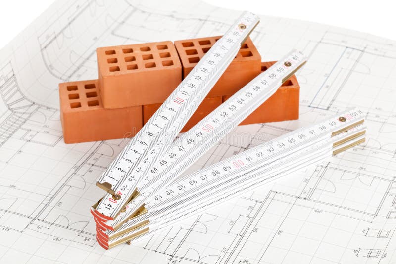 Open white folding rule with small bricks on building plans. Exact range stock images, royalty-free photos and pictures