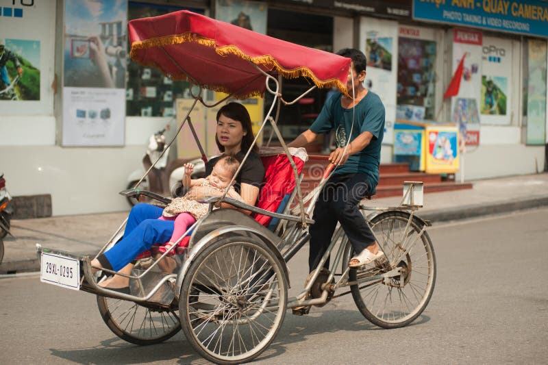 Folk i området som tar en cyclo ritt i Hanoi, Vietnam royaltyfria foton Folk i området som tar en cyclo ritt i Hanoi, Vietnam royaltyfria foton