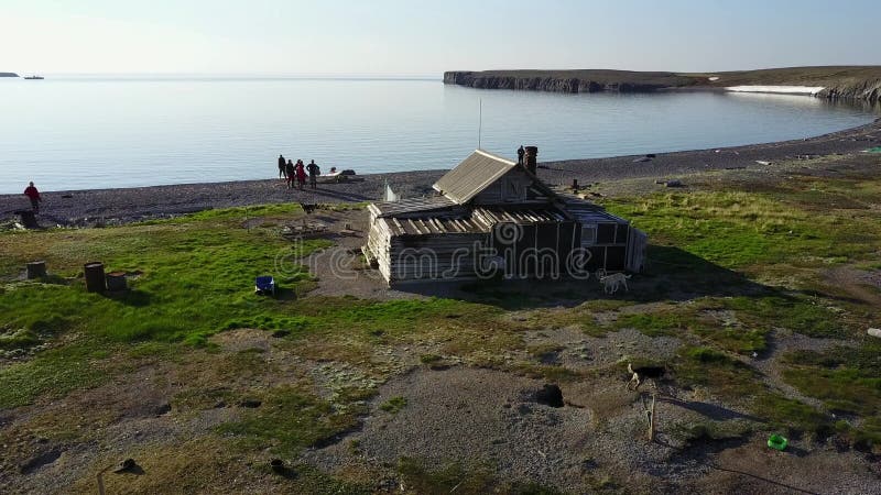 Folk nära ensamt hus på den ensamma Vaygach ön i öken