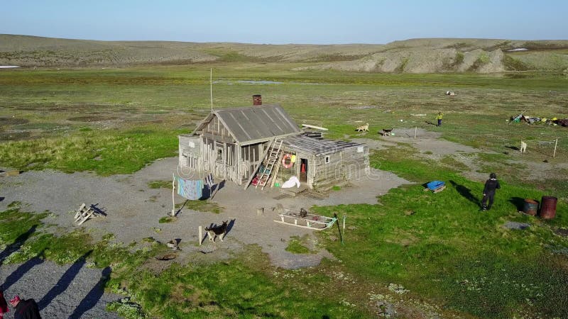 Folk nära ensamt hus på den ensamma Vaygach ön i öken