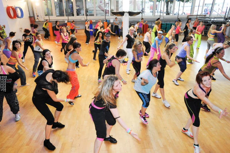 Folk som dansar under Zumba utbildningskondition på en idrottshall royaltyfri fotografi Folk som dansar under Zumba utbildningskondition på en idrottshall royaltyfri fotografi
